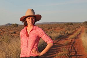 Anika Molesworth in hat on a red dirt road