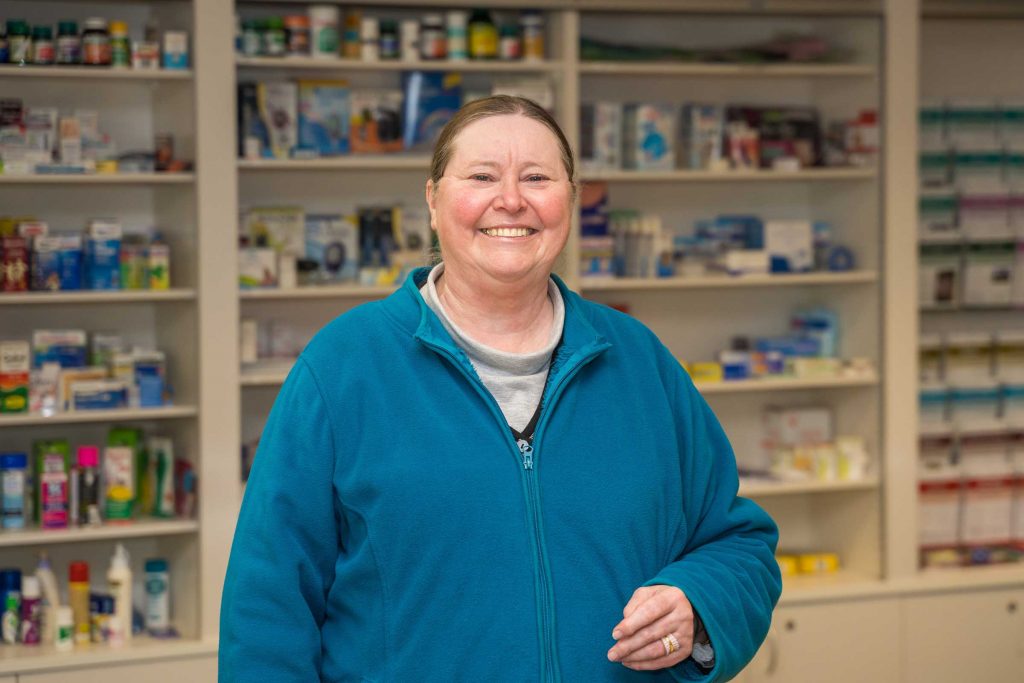 Mareer Donna Simpson standing in front of a pharmacy display