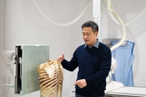 Dr Xiaoming Zheng with an X-ray machine.