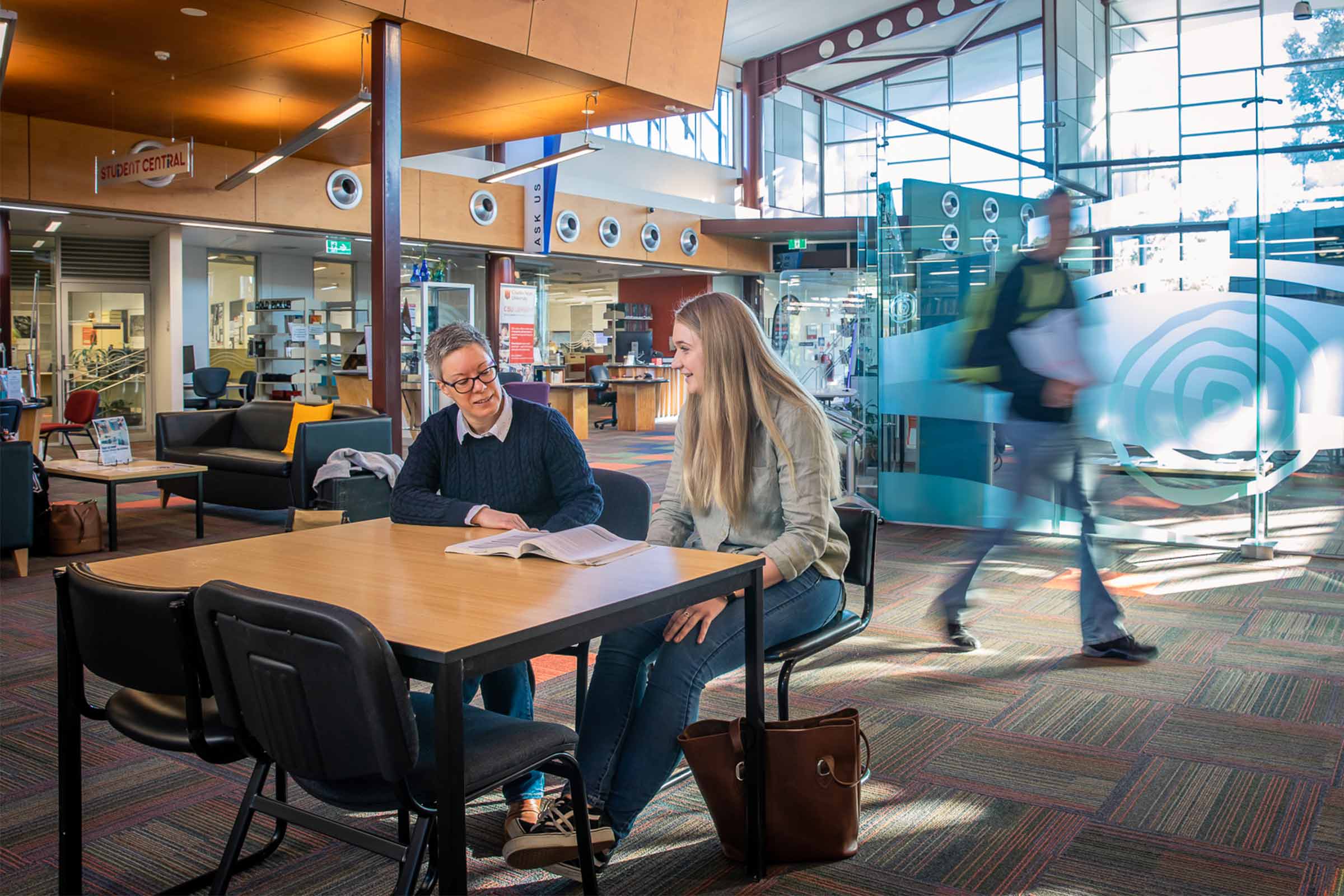 Two students sitting at a library table studying. These facilities can be used by Charles Sturt University online law students.