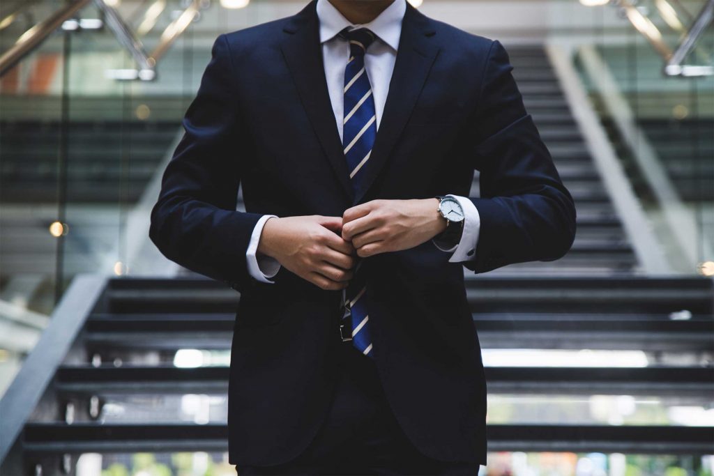 Professional man in a suit buttoning his jacket ready for to get promoted.