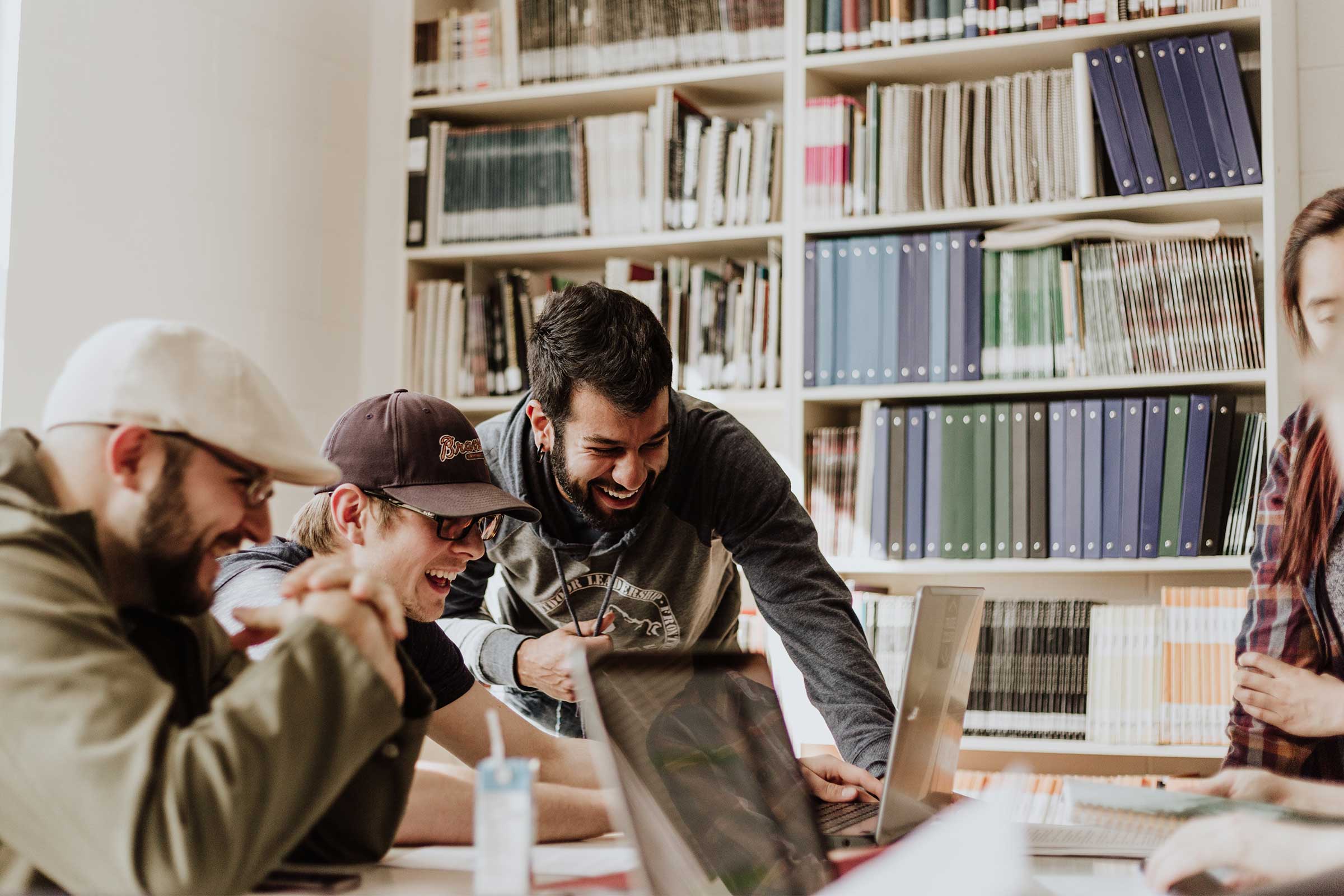 Group of students around a laptop looking at alternatives in the bachelor of communication