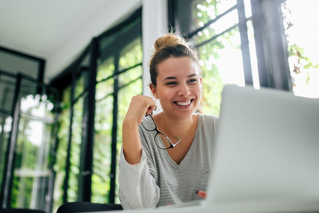 Smiling woman looking at her laptop.