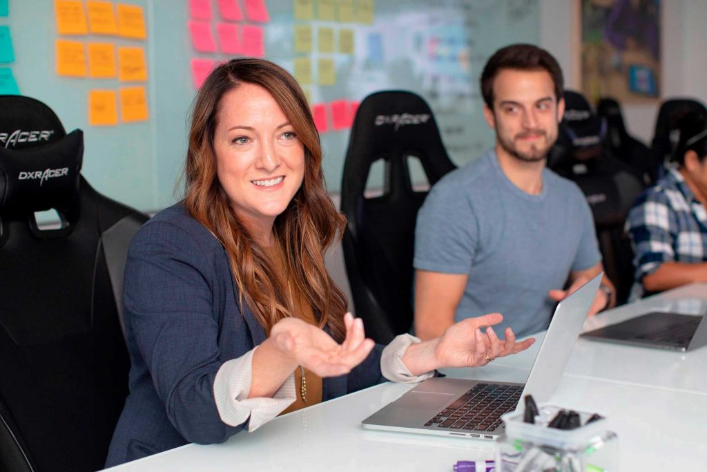 Two people sitting in an office in front of a whiteboard