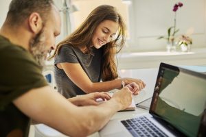 Father and daughter at a laptop planning paying for university costs in Australia