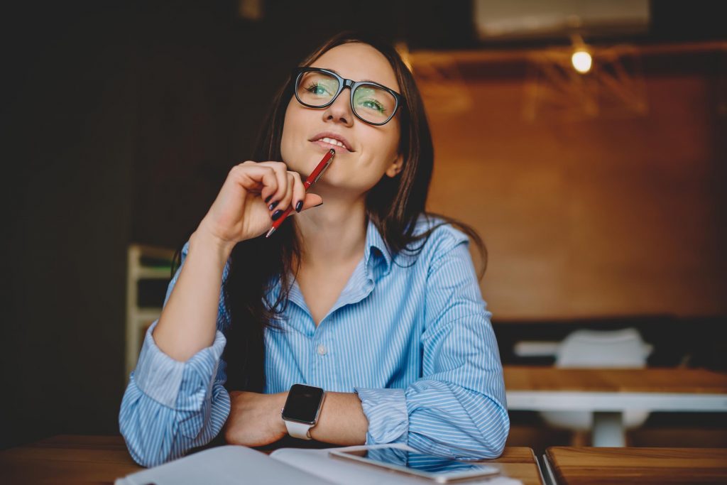 young woman thinking about university study wearing a blue shirt