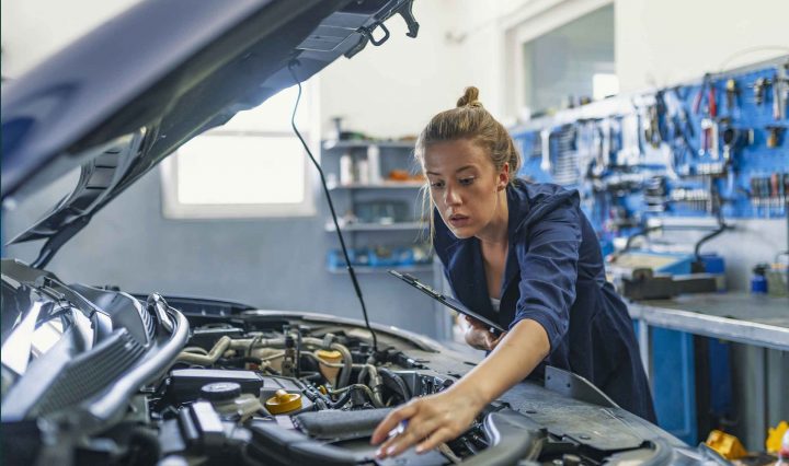 Woman mechanic working on a car engine, challenging traditional gender norms