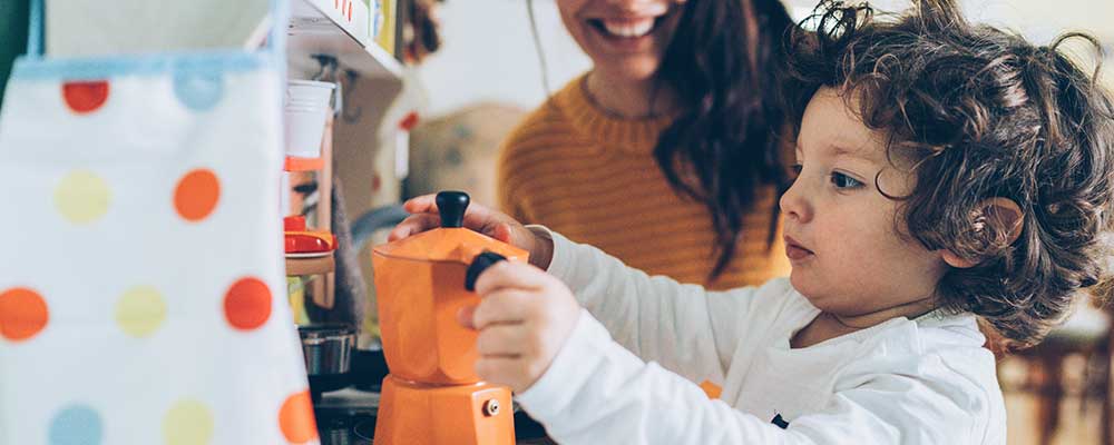 Young mother going against the norm teaching her son domestic tasks