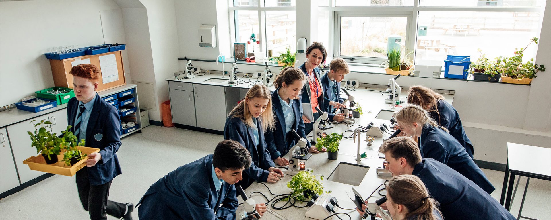 Students gathered around a bench in a science lab
