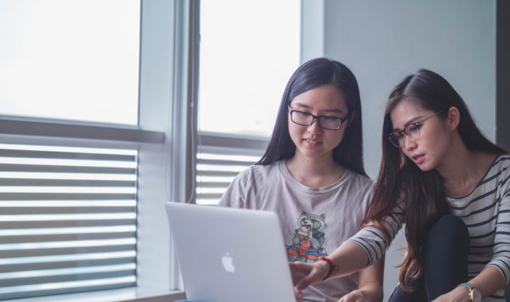 Two young women in front of a laptop discussing what is a USI number