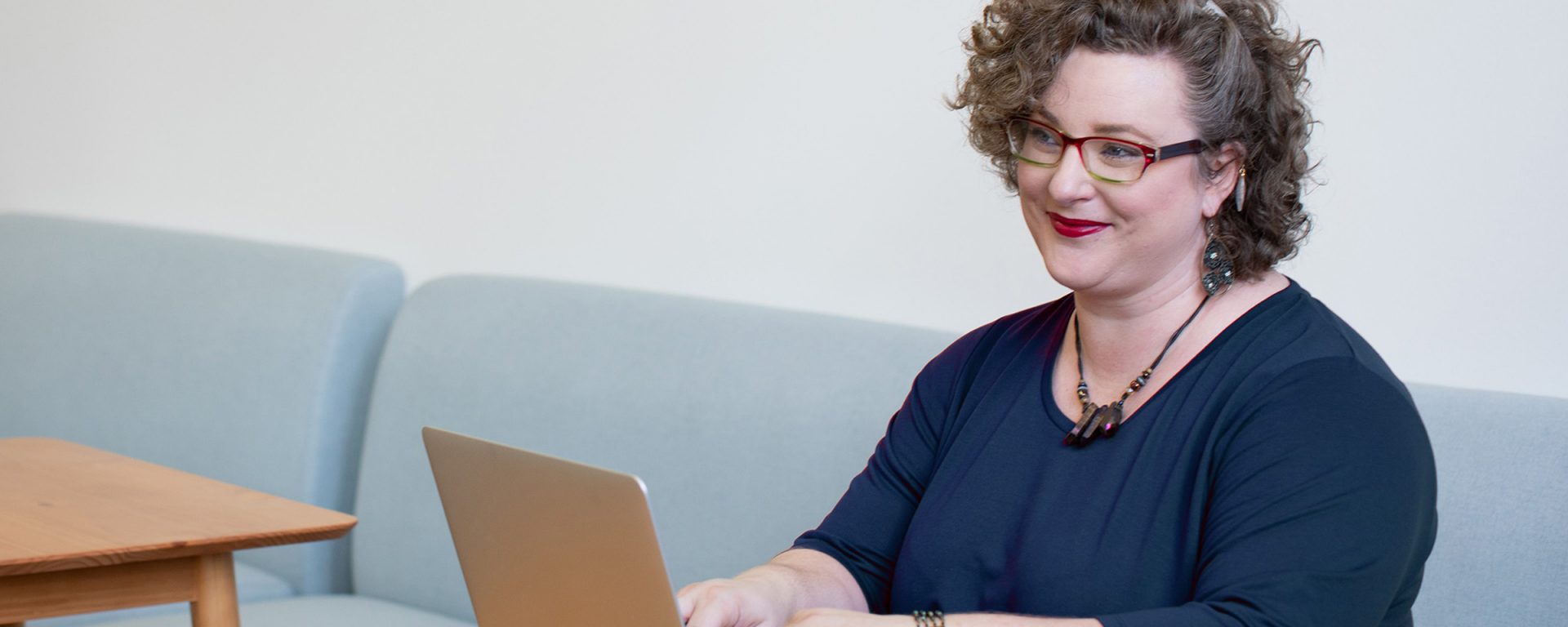 Woman sitting at a laptop, representing the question why study a postgraduate degree