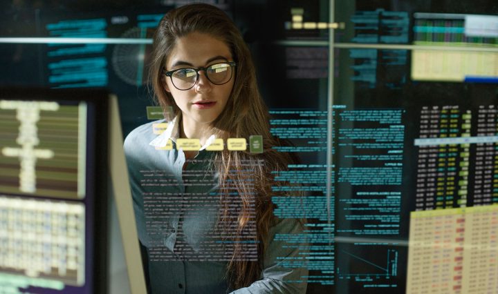 Woman working in IT and cyber security looking a data on a computer screen