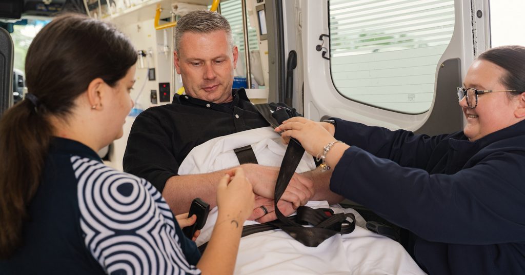 Paramedic helping man on stretcher