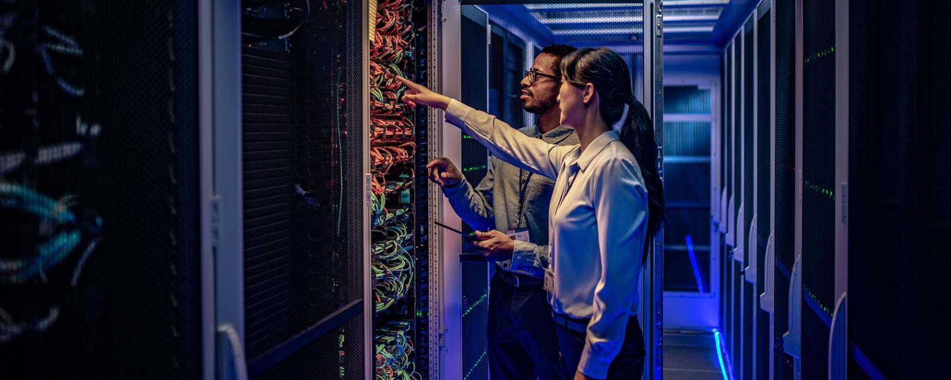 A woman and a man in front of a computing array, representing the future of information technology