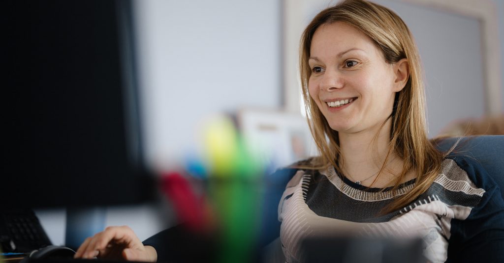 Woman smiling at a computer