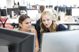 two women working together at computers