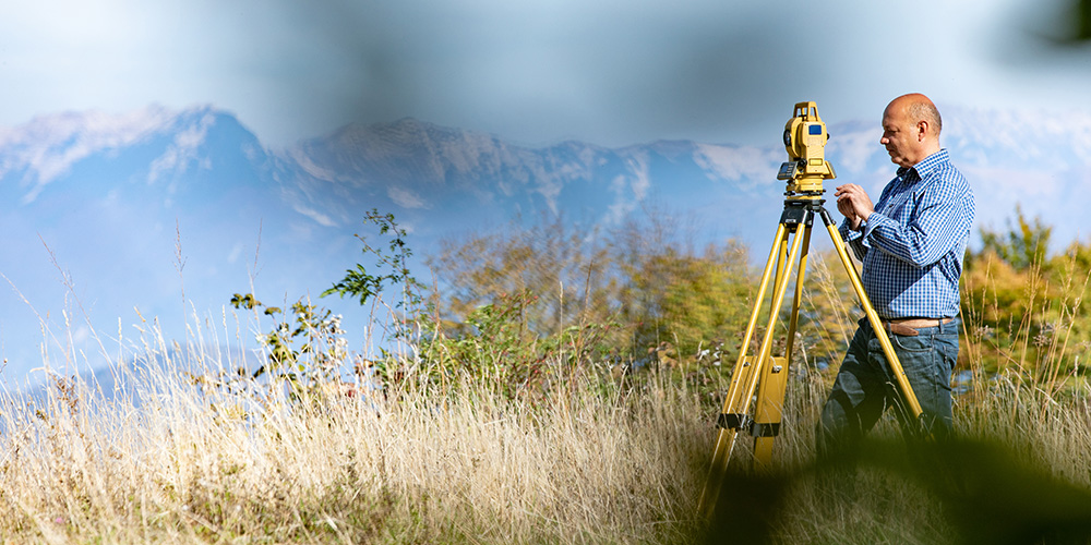 A geospatial scientist surveying land as part of his career in sustainability