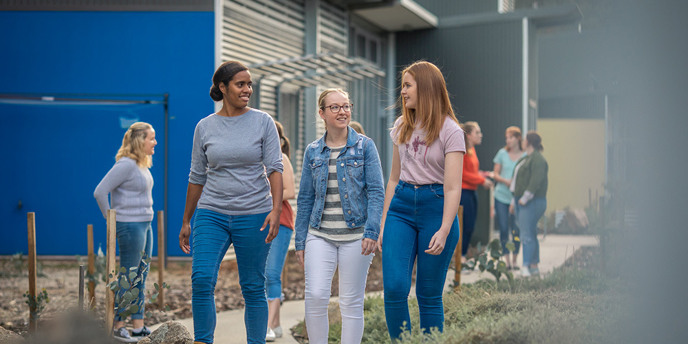 A group of students walk between accommodation buildings on Albury-Wodonga campus.