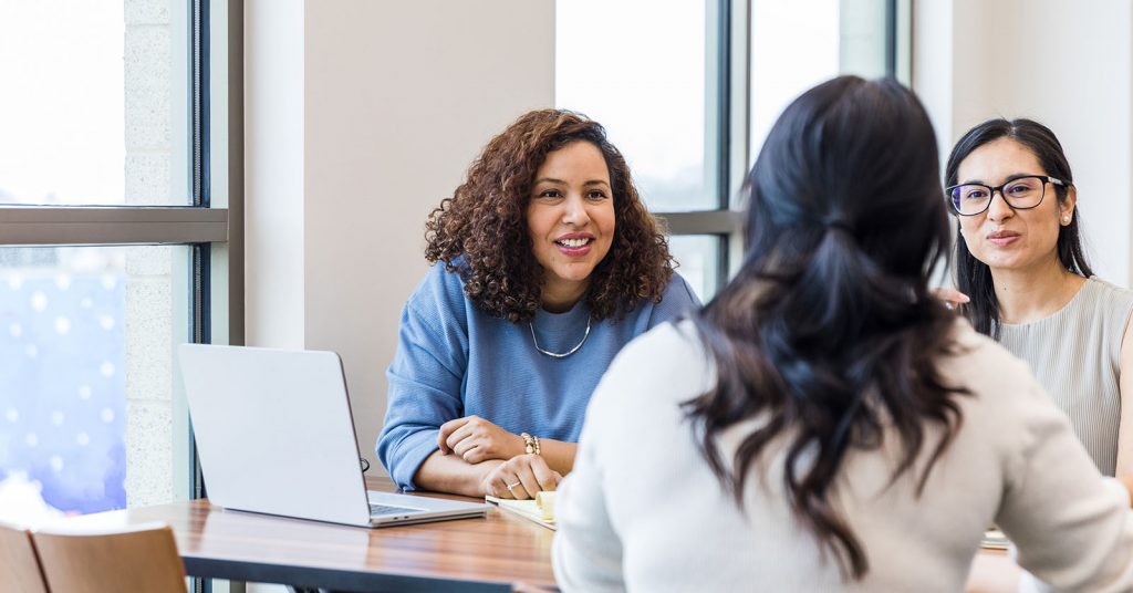 A woman studying discussing notes with other students