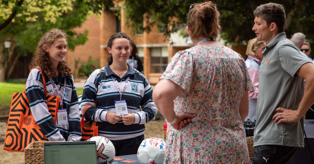 Two Year 12 students talking to Charles Sturt staff members about uni for Explore Day