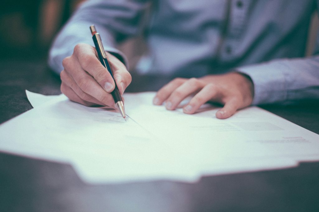 Male hands writing on a piece of paper about dirty money