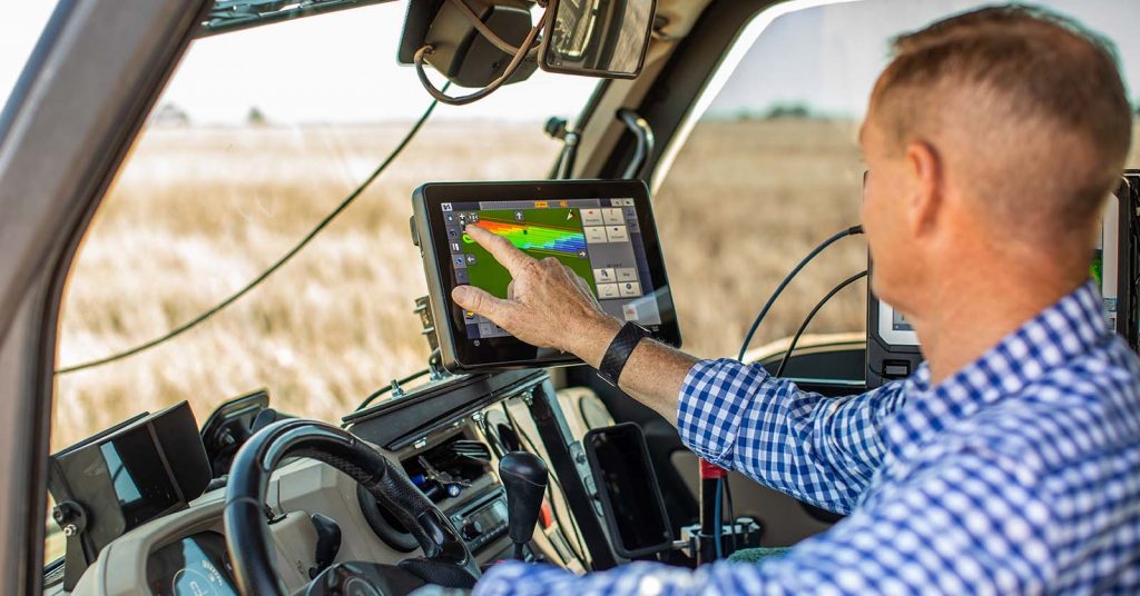Horticultural extension agent looking at a tablet screen in a vehicle