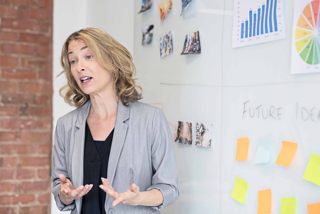 Woman in front of a white board discussing data analytics