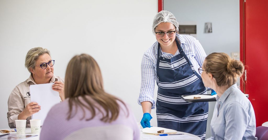 Woman serving three other women a meal