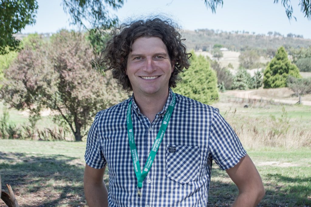 Person in front of green landscape