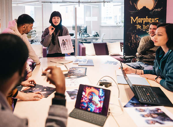 Group of video game developers working on designs around a table