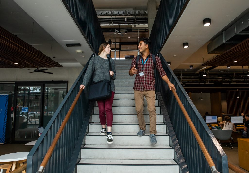 Two students walking down stairs