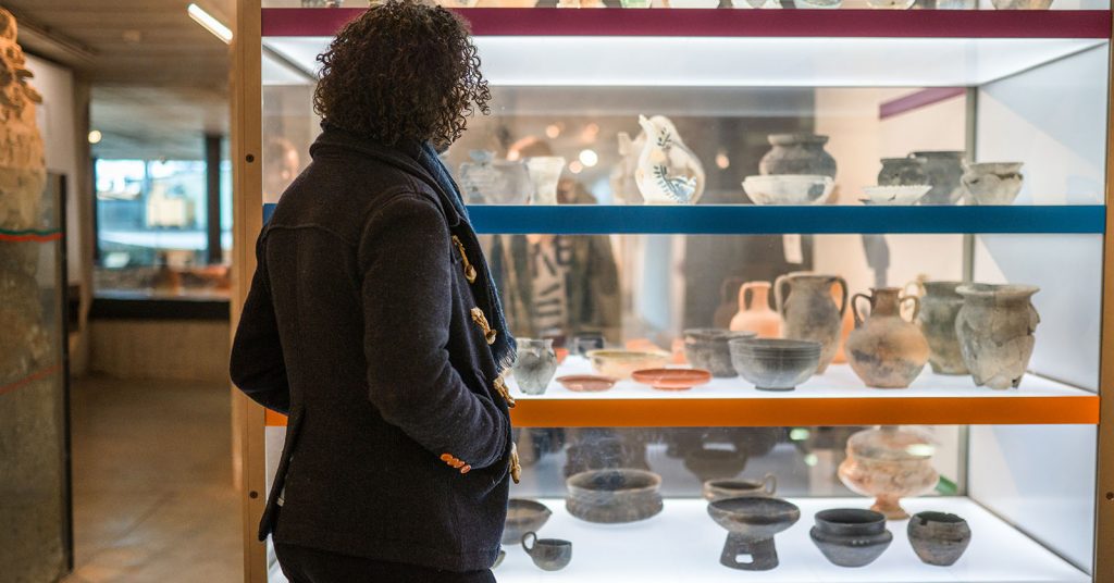 Man looking at artifacts in a vitrine