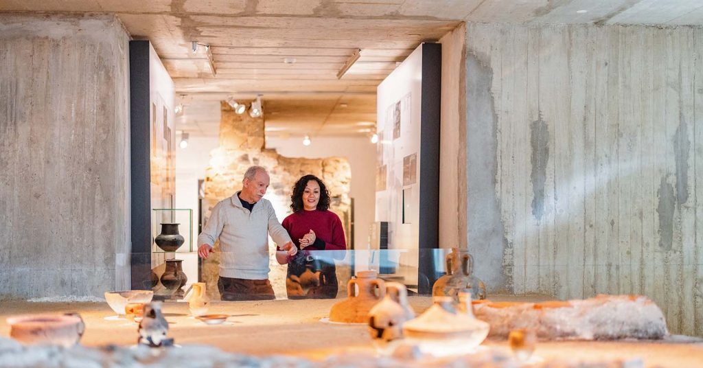 Man and woman looking at pottery in a museum