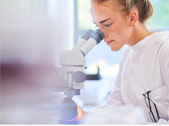 Woman looking into microscope