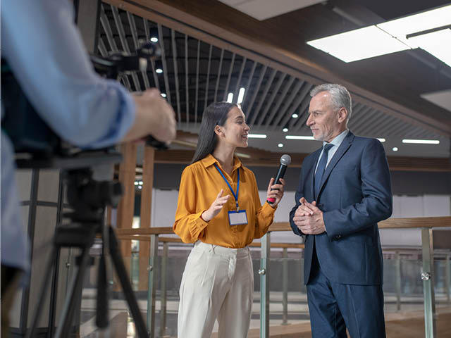 Woman interviewing man in front of a camera