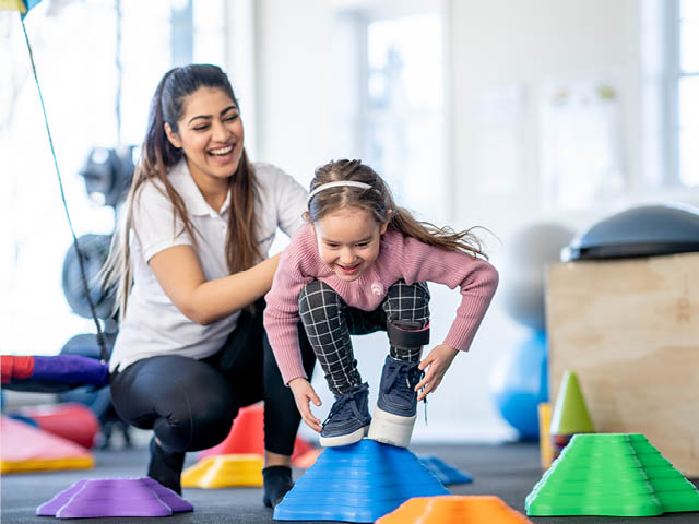 Woman helping child play