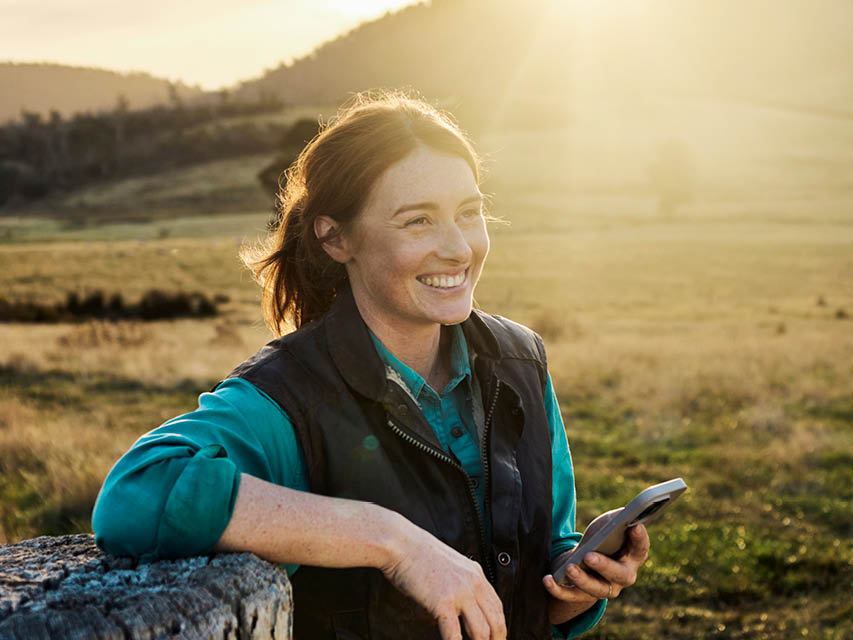 Woman in field with a mobile phone