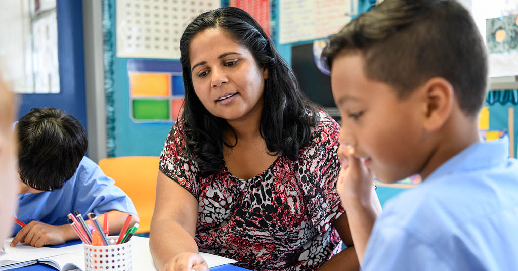 Female kindergarten teacher instructing a pupil