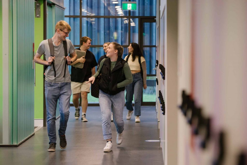 A group of students walking down a university corridor