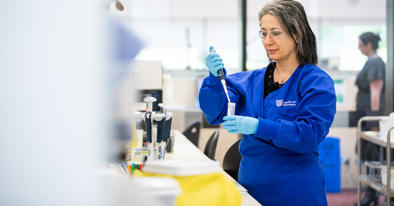Female scitentist using a pipette and a test tube in a labratory