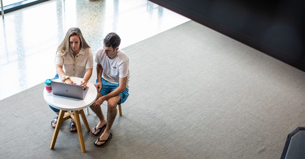 Woman and man sitting in front of a laptop