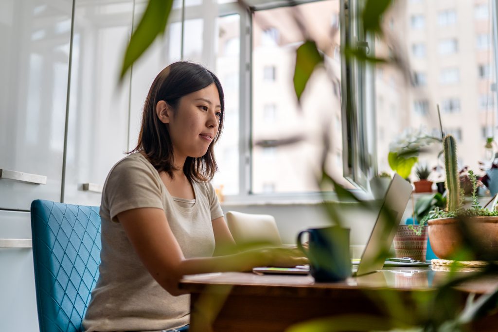 Woman sitting at a desk typing on a laptop