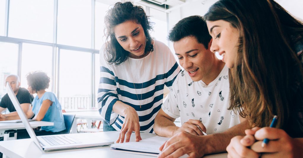 Students studying together with books and laptops.