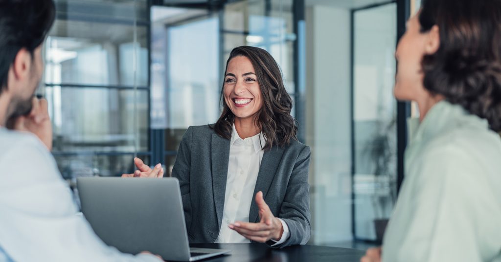 women in meeting at desk with laptop