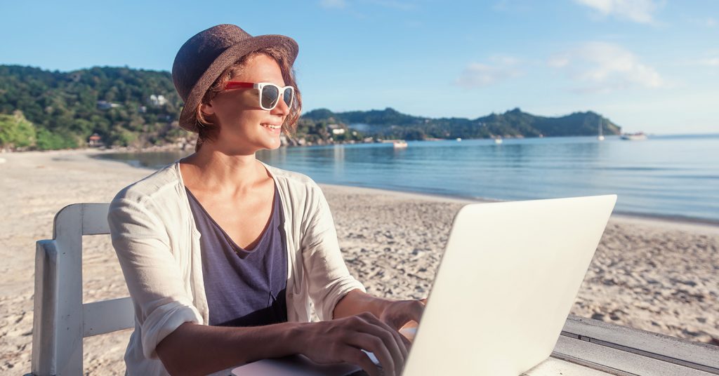 woman on laptop at the ocean