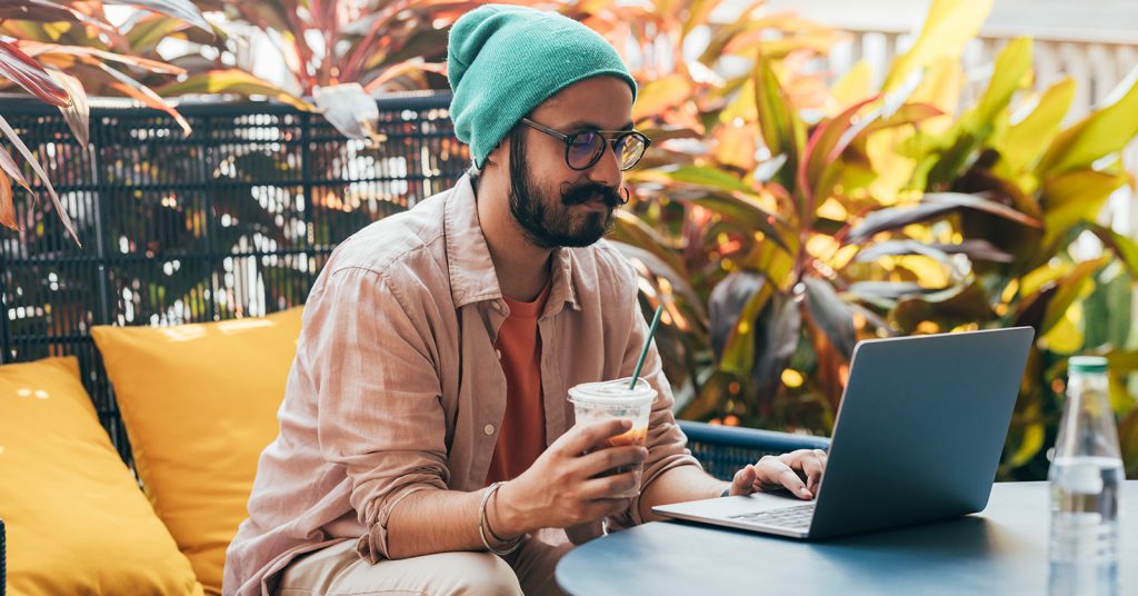 man working on laptop with drink