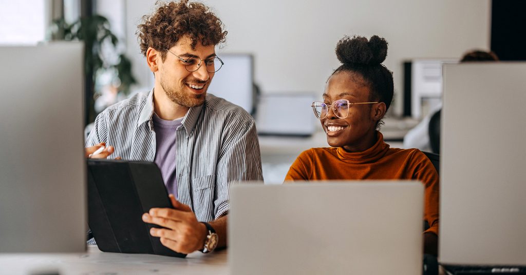 A man and woman working on computers