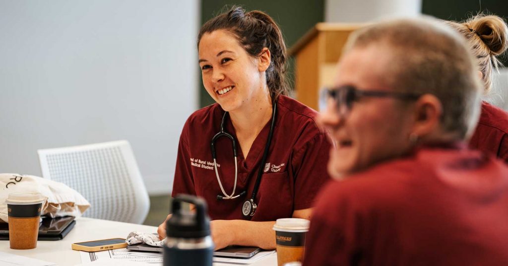 A female medicine student smiling in a classroom. 