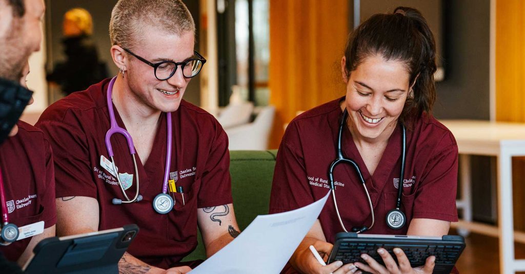 Two medicine students smiling while in a group.