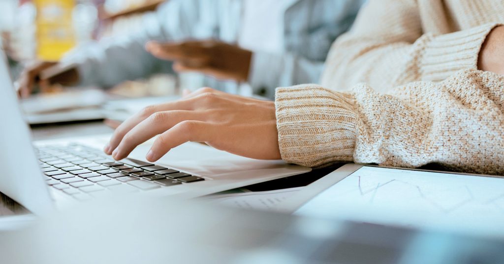 Hand typing on laptop